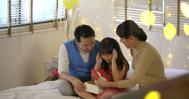 Heureuse famille asiatique célébrant les filles cadeaux d'ouverture d'anniversaire et se réjouir sur le lit . — Video