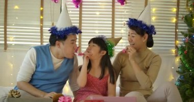 Mutlu genç aile üfleme parti boynuz üfleyiciler.