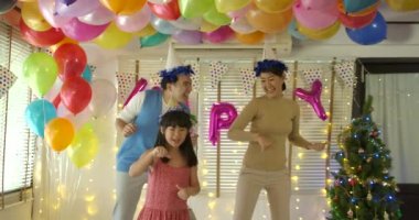 Mutlu Genç Asyalı aile birlikte evde parti etkinliğinde dans.