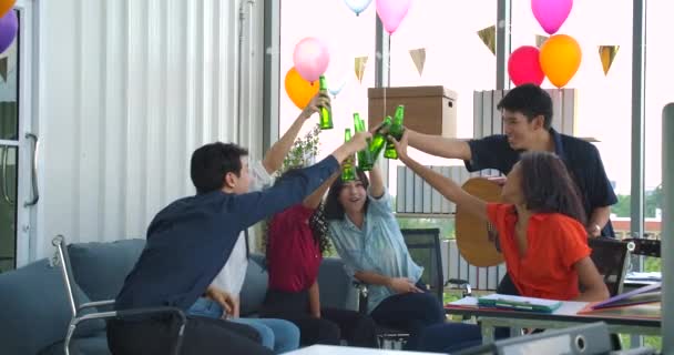 Equipo de jóvenes bailando y divirtiéndose celebran con brindis y tintineo levantando vasos en su oficina . — Vídeo de stock