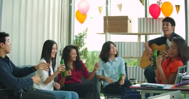 Une équipe de jeunes danse et s'amuse à célébrer avec des toasts et des lunettes levantes dans leur bureau . — Video