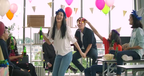 Команда молодых людей танцует и веселится, празднуя с тостами и звоном поднимая бокалы в своем офисе . — стоковое видео