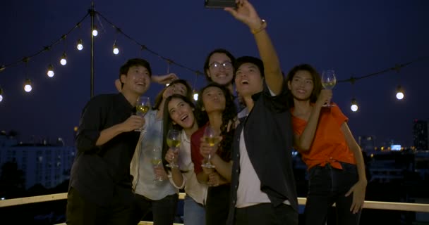 Grupo de jovens amigos dançando e se divertindo celebrando o Ano Novo e o Festival de Natal juntos na festa de verão no telhado . — Vídeo de Stock