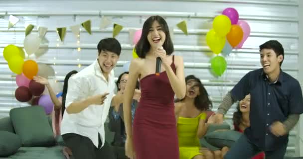 Skupina mladých přátel protřepání k hudbě a zpěvu do mikrofonů, když tráví čas spolu v karaoke baru — Stock video
