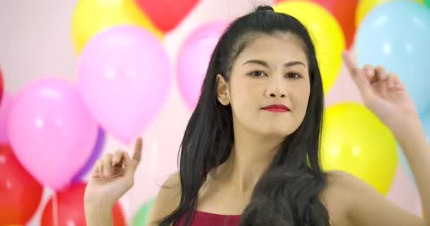 スローモーションでパーティーでカラフルなバルーン バック グラウンドで踊る美しいアジアの女性. — ストック動画