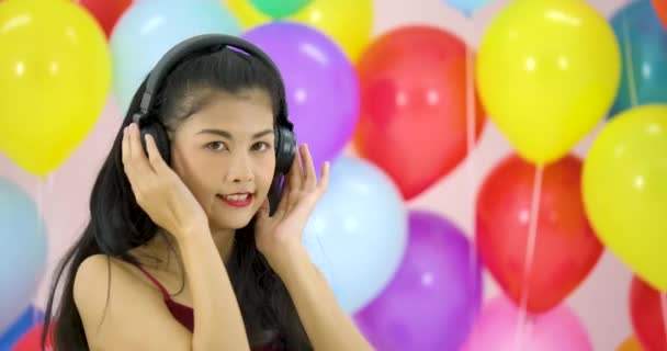 Belle femme asiatique dansant avec fond de ballon coloré à la fête au ralenti . — Video