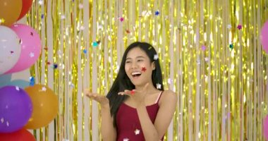 Güzel Asyalı kadın zevk konfeti ile altın glitter arka plan üzerinde.