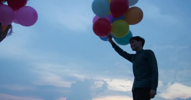 Young couple people holding balloon with sunset background. — Stock Video
