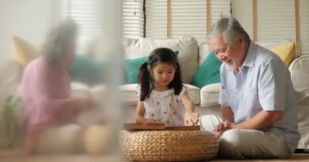 Азиатская старшая пара играет вместе с маленькой девочкой дома . — стоковое видео