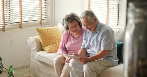 Niña viene a abrazar a su abuelo y abuelo mientras juegan tableta. Niño jugando con el hombre y la mujer mayores con emoción feliz . — Vídeo de stock