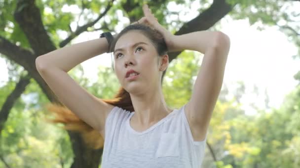 在城市公园晨跑前 亚洲年轻女子的运动年轻女子把头发拉直 运动健康生活方式理念 — 图库视频影像