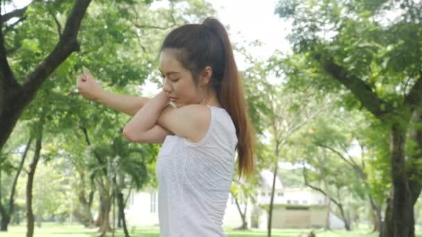 운동 젊은 아시아 여자 워밍업 하 고 공원에서에 운동 하기 전에 스트레칭. — 비디오