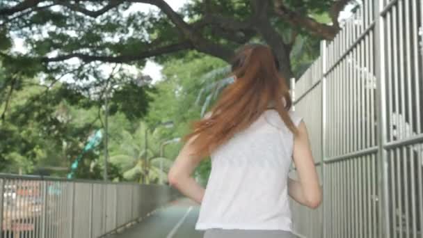 Sportos fiatal ázsiai nő bemelegítés és nyújtás napkeltekor edzés előtt a Városligetben. — Stock videók
