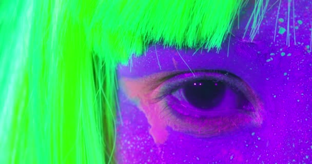 Nahaufnahme weibliche Augen mit fluoreszierendem Make-up in grün, Perücke, kreatives Make-up sieht toll für Nachtclubs aus. — Stockvideo