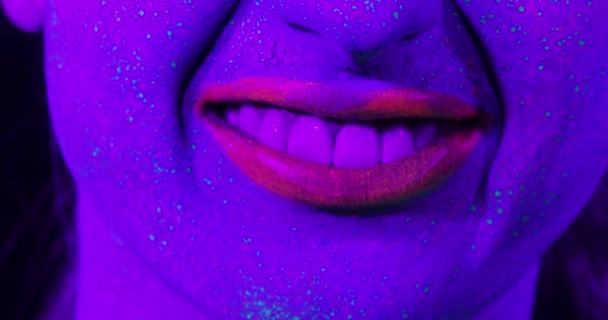 Los labios de mujer de primer plano con maquillaje fluorescente, maquillaje creativo se ven muy bien para los clubes nocturnos . — Vídeos de Stock