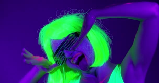 Slow motin of beautiful sexy women with fluorescent make-up and clothing dancing in neon light. — Stock Video