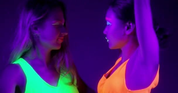 Powolne motin piękne sexy kobiet z fluorescencyjny makijaż i ubrania taniec w świetle neon. — Wideo stockowe