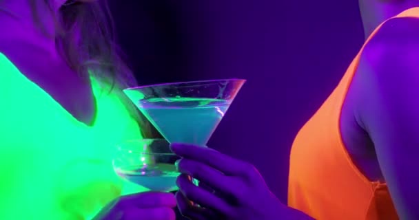 Trage motin van mooie sexy vrouwen met fluorescerende make-up en kleding dansen in neon licht. — Stockvideo