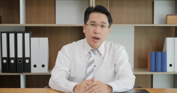 Attractive Asian man recording video message talking on webcam, consultant making offer to client by video call, vlogger recording videoblog, training for effective business introduction — Stockvideo