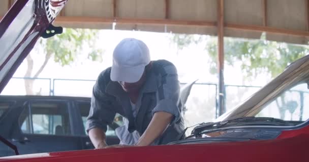 Hombres profesionales mecánicos reparando un coche en un garaje. concepto de servicio de coche — Vídeos de Stock