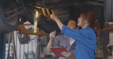 Profesyonel mekanik ekibi altında kaldırdı araba oto tamir dükkanında çalışıyor.