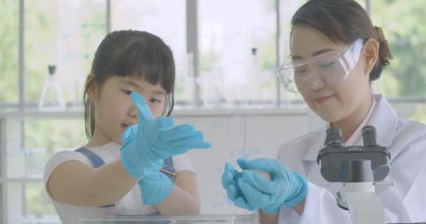 Pequeña estudiante asiática aprendiendo sobre rata de laboratorio en la clase de laboratorio experimento de ciencia . — Vídeo de stock