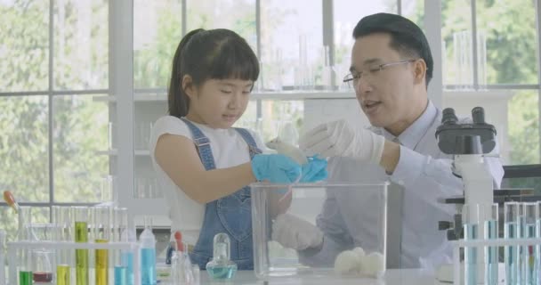 Little Asian student girl learning about laboratory rat in science experiment laboratory class.