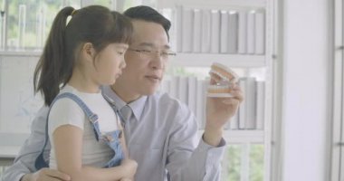 Öğrenme anatomi dersi çene modeli ile insan iskeleti hakkında küçük Asya öğrenci kız.