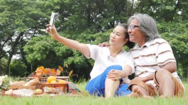 Üst düzey Çift Karı koca smartphone için selfie Park'ta birlikte kullanarak. İnsanlar yaşam tarzı, emeklilik yaşı ve sevgi ile.