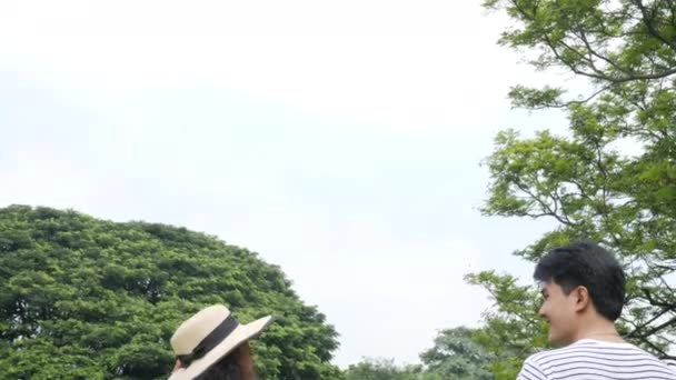 Joven pareja asiática disfrutando en primavera día en la naturaleza y yendo de picnic con emoción feliz . — Vídeos de Stock