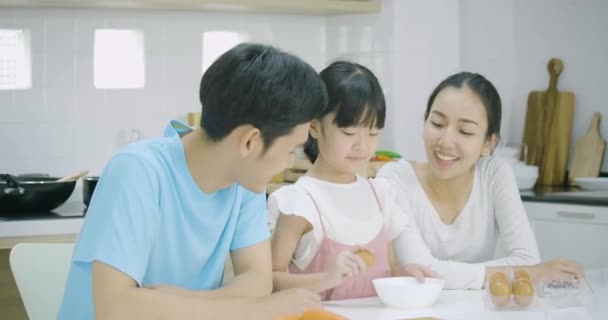 アジアの父の笑みを浮かべて 母と娘楽しんで台所で一緒に健康的な夕食を準備します 母娘に料理を教える — ストック動画
