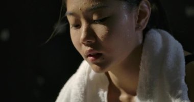 Vücut geliştirmeden sonra dinlenen güçlü atletik kadın ya da soyunma odasında tek başına egzersiz yapan kadın. yavaş çekim.