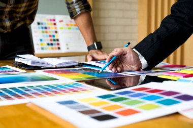 Grafik tasarımcıları, tasarım fikirleri için renk çubuğu örneğinden, grafik tasarımcıların yaratıcı tasarımlarından renk seçmek için tableti kullanır..