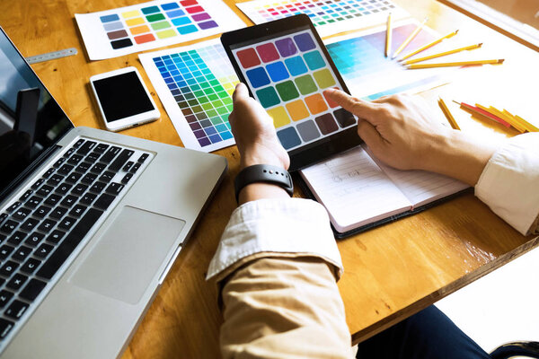 Graphic designers use the tablet to choose colors from the color bar example for design ideas, Creative designs of graphic designers concept.