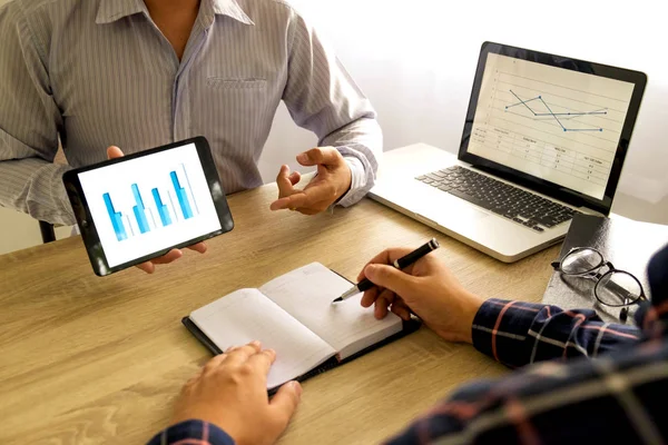 Businessman using tablet to teach and  analysis the situation on the market value , Business concept