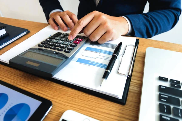 İş adamları ihracat işinin gelirini ahşap masa üzerinden hesaplar. İş konsepti..