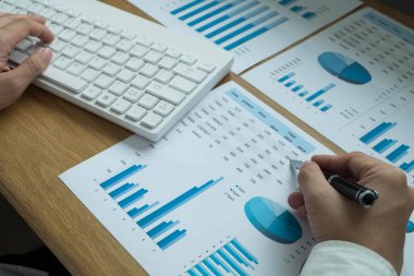 İş adamları iş sonuçlarında rakamları, grafiği ve grafiği işaret ediyorlar. İş konsepti.