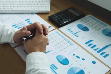 İş adamı ahşap masa üzerinde gelir beyannamesi ile çalışıyor. İş konsepti..