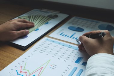 İş adamları iş sonuçlarında rakamları, grafiği ve grafiği işaret ediyorlar. İş konsepti.