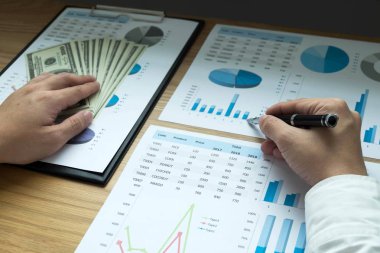 İş adamları iş sonuçlarında rakamları, grafiği ve grafiği işaret ediyorlar. İş konsepti.