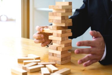 Eksik dominos doldurun ve domino başarısız korumak için dominoe blok seçmek iş adamları. Büyüyen iş kavramı.