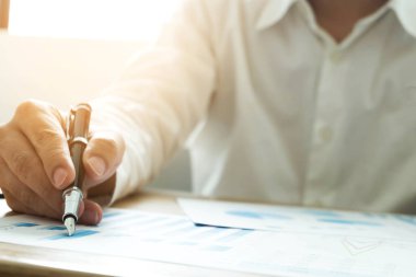 İş adamları iş sonuçlarında rakamları, grafiği ve grafiği işaret ediyorlar. İş konsepti.