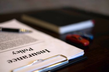 Nesne sigorta araba kavramı kapatın. klibi kurulu, Not defteri, kalem ve belgeler üzerinde çalışma tablosu ile sigorta araba.