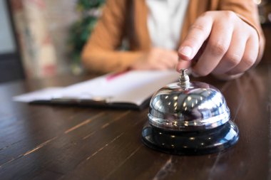 Kadın otel resepsiyonu parmak itme bir çan ile lobi otel ara. otel konsepti.
