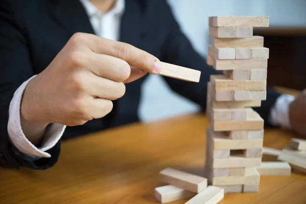 Eksik Domino doldurmak için ahşap bloklar tespit iş adamları. Büyüyen iş kavramı.