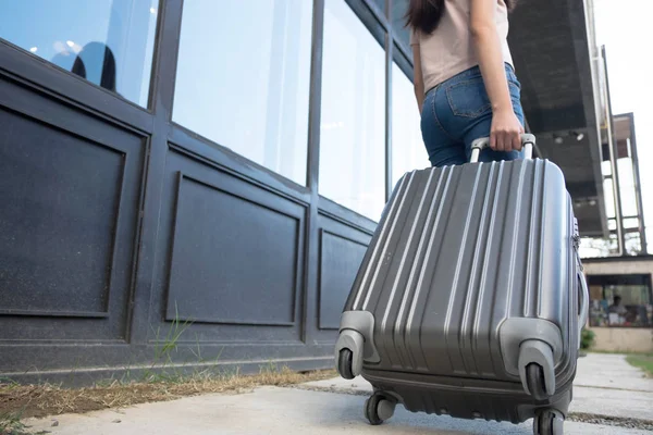 Woman with travel trolley luggage in hotel lobby.Travel concept.