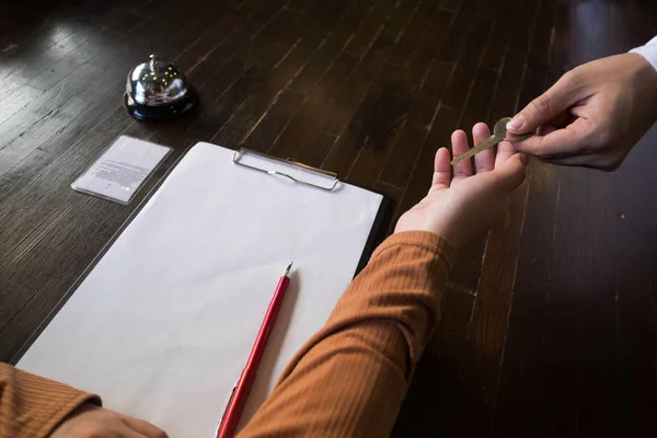 Close up of hand guest takes room key at check-in desk of the ho