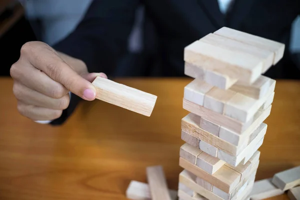 Üzletemberek szedés fa blokkok, hogy kitöltse a hiányzó dominó. Gr — Stock Fotó