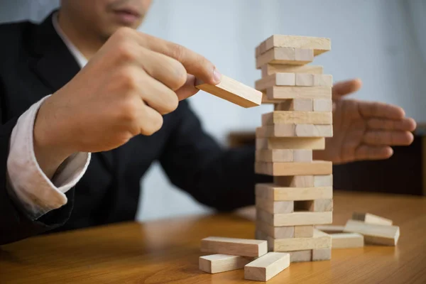 Businessmen picking wood blocks to fill the missing dominos and — Stock Photo, Image