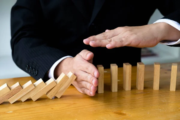 Business hand stops domino continuous overturned meaning that hi — Stock Photo, Image